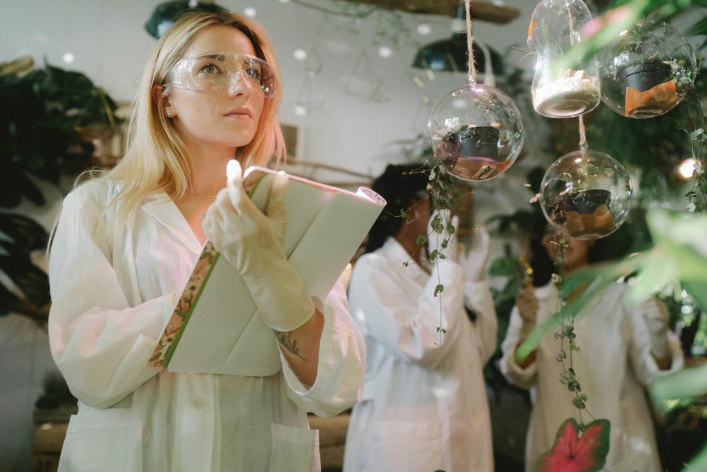 Female scientist observing plant experiments in a lab setting.